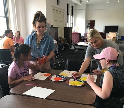 YOLO FFB Activity 1 Two adults helping girls with a painting project
